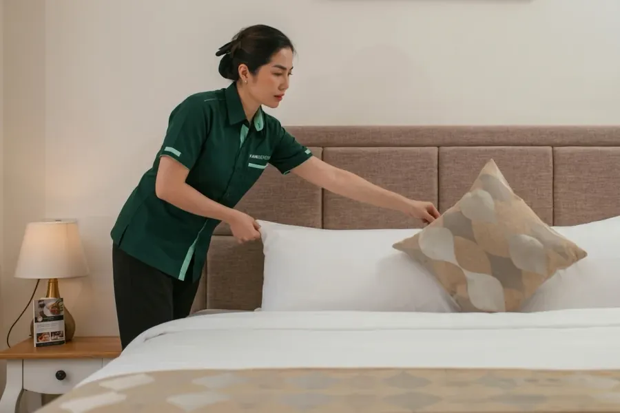 Staf housekeeping KamiBeresin merapikan kamar hotel
