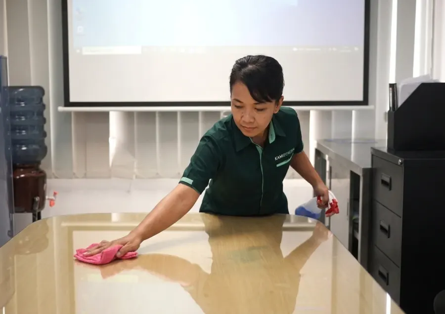Office boy KamiBeresin membersihkan meja kerja di kantor